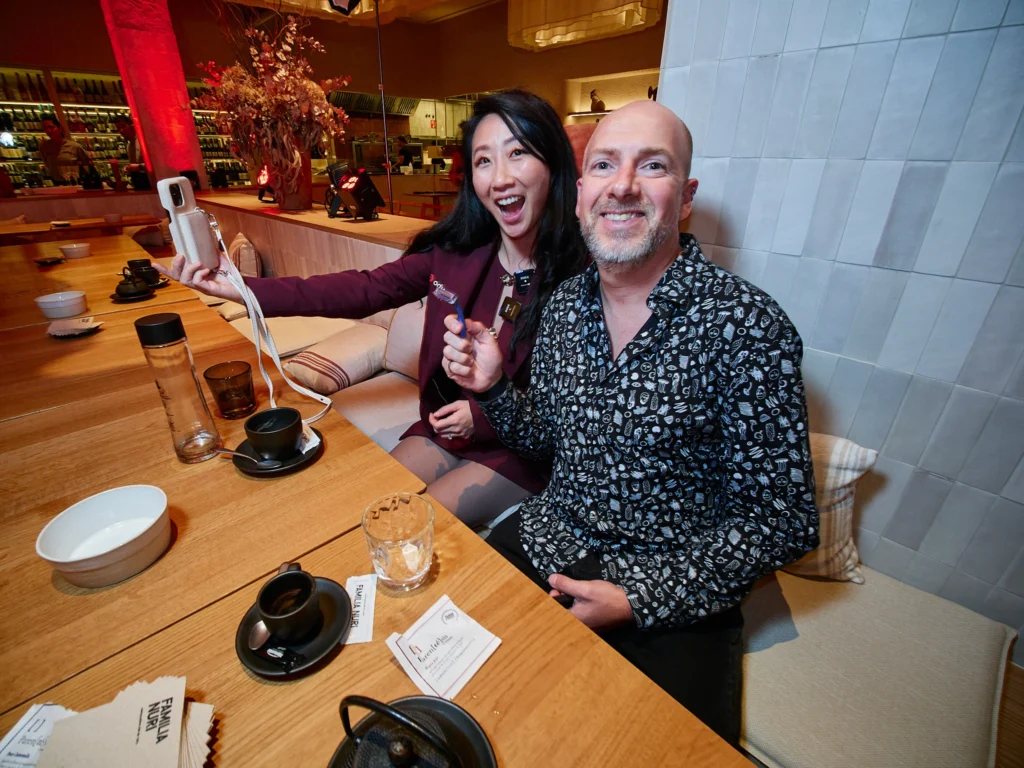 Odys team member and client in discussion, both pausing to smile for the camera during the buffet reception in Port Vell.