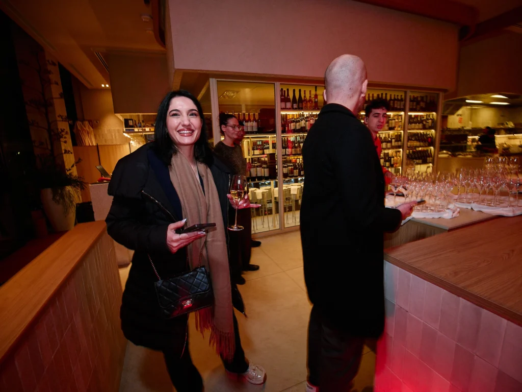 A female tech executive looks confidently at the camera during the Odys corporate client evening, with Nuara's sophisticated mood lighting in the background.