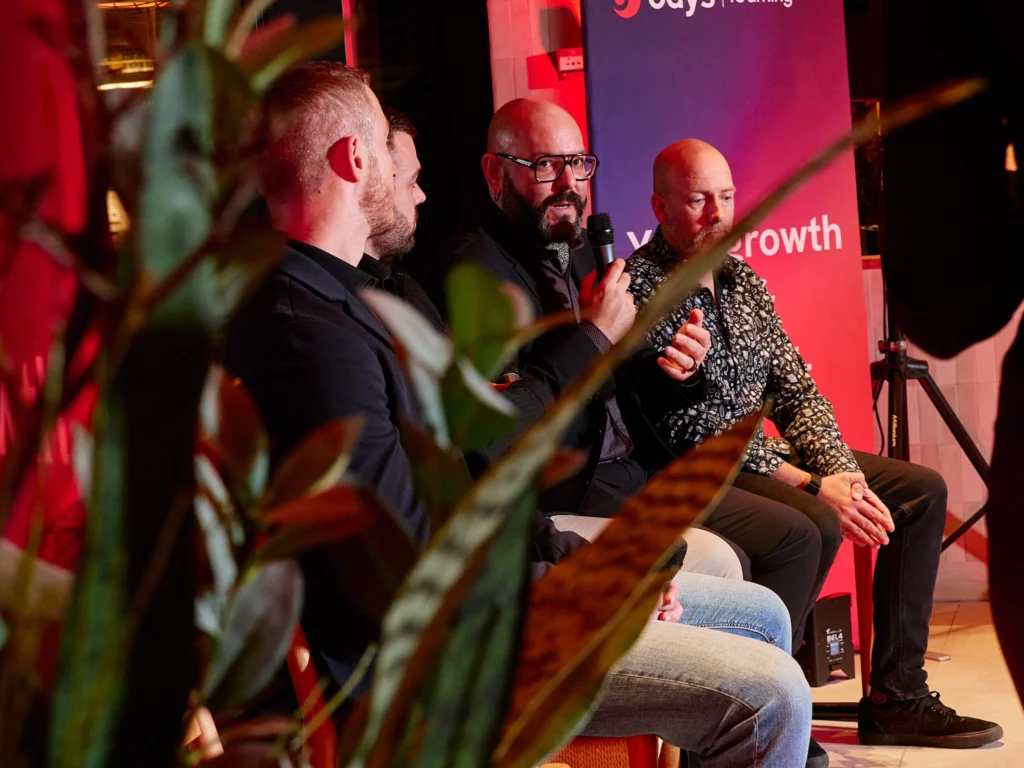 Odys team member and client in discussion, both pausing to smile for the camera during panel discussion in Port Vell