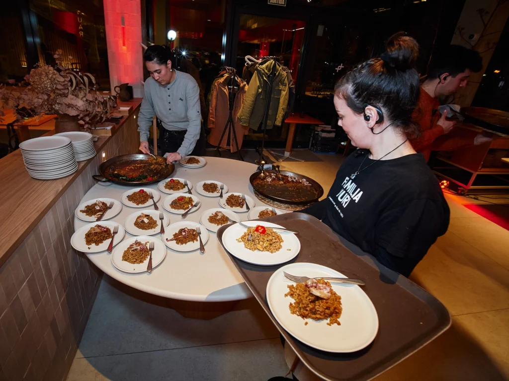 Waitress collecting plates at Nuara restaurant in Barcelona's Port Vell.