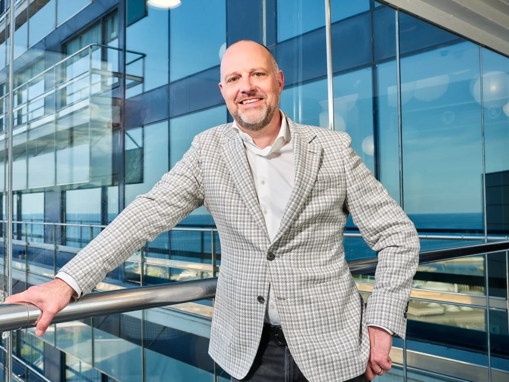 Corporate headshot of a business executive in a modern Barcelona hotel.
