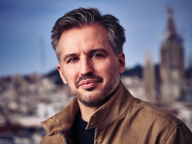 A man photographed with the Sagrada Familia in the background