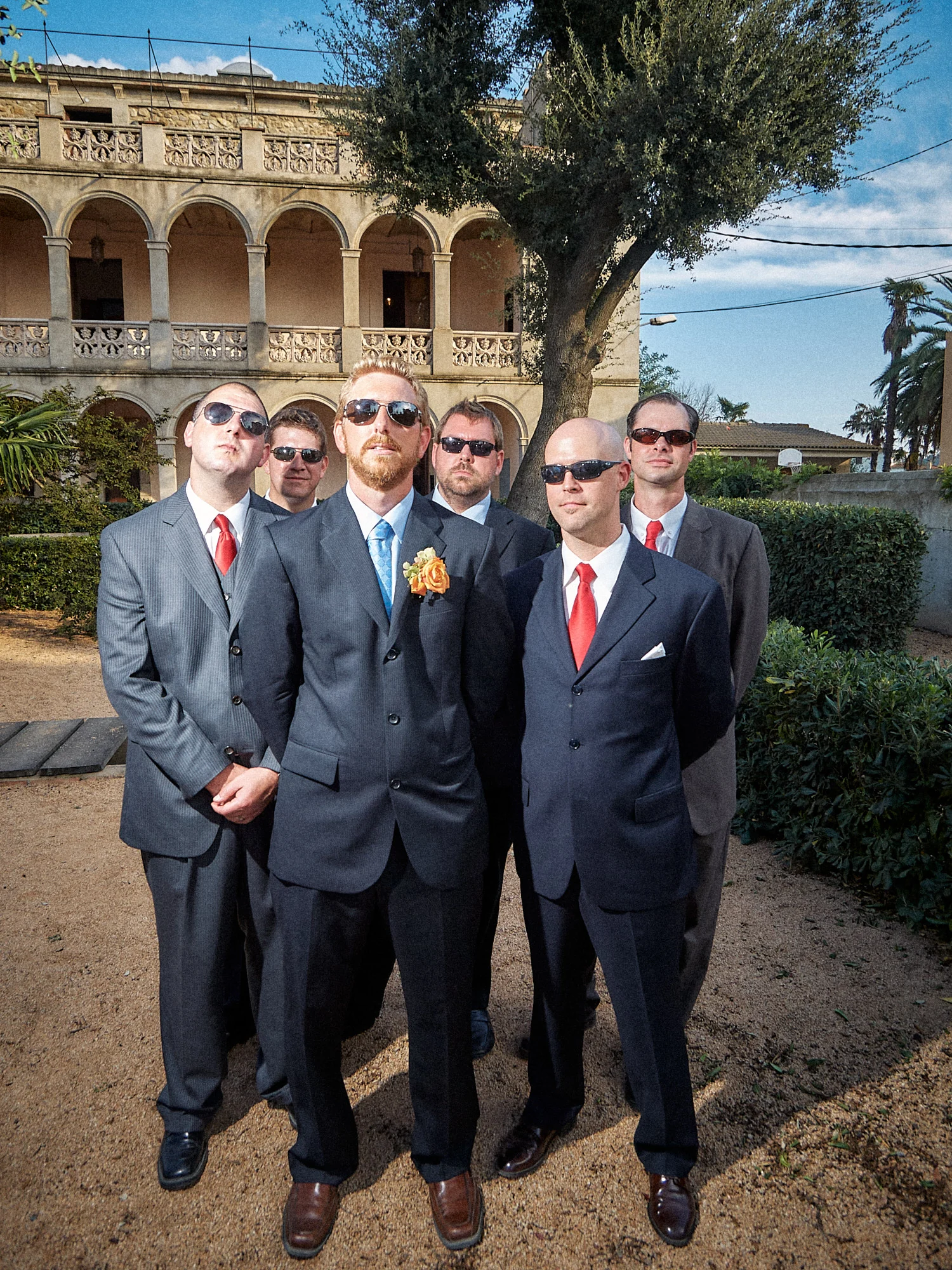 Four wedding guests in suits outside Can Tallada