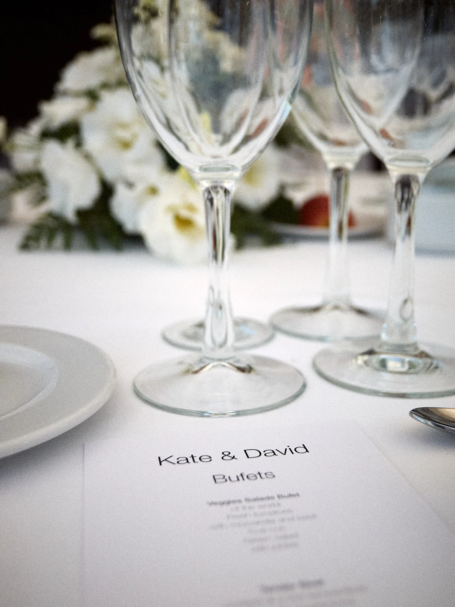 Wine glasses and printed menu on a wedding table at Can Tallada