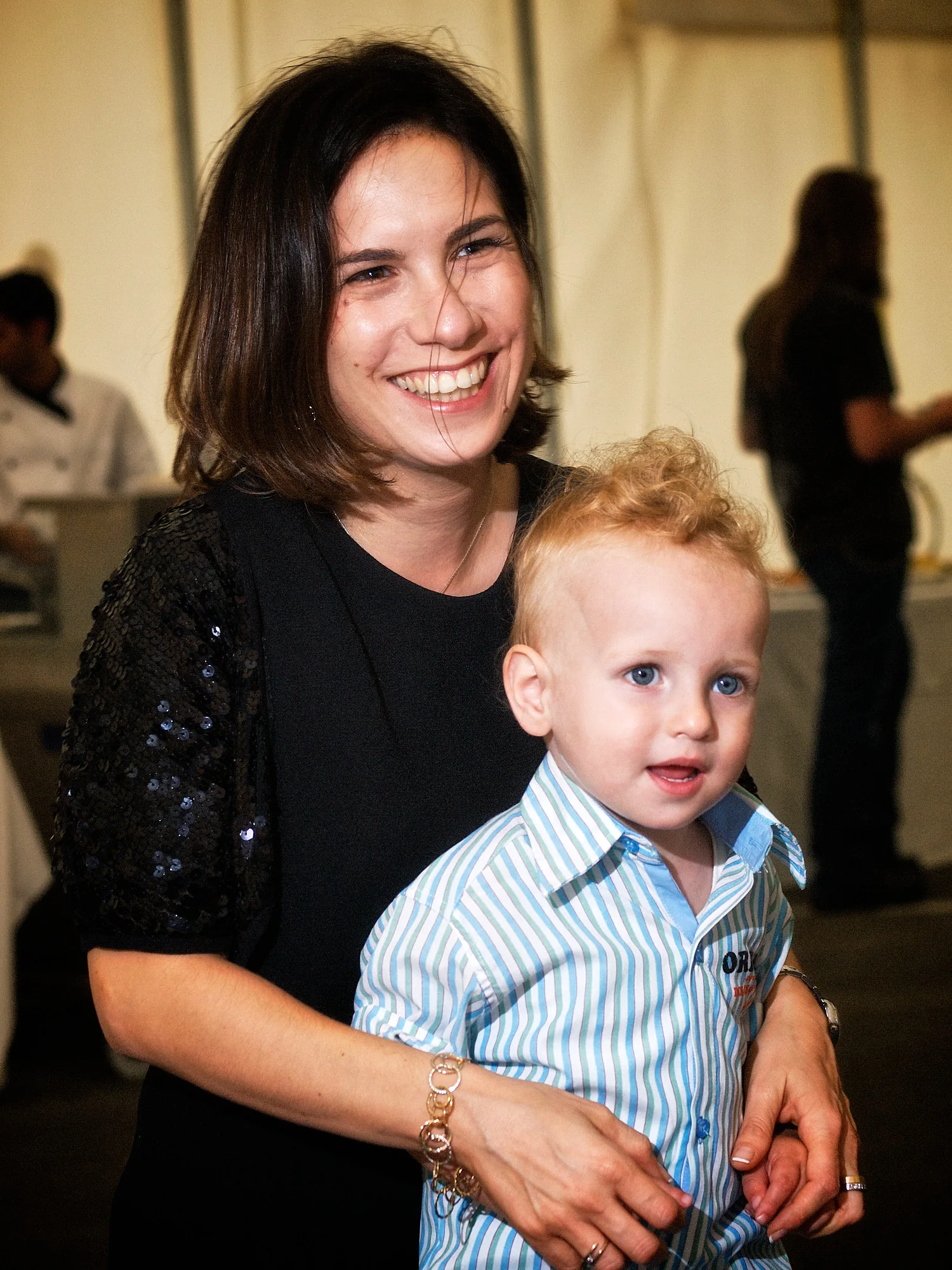 Emily & Regis Cardona Wedding – Forum Family A woman holding a young child at Emily and Regis’ pre-wedding Forum gathering