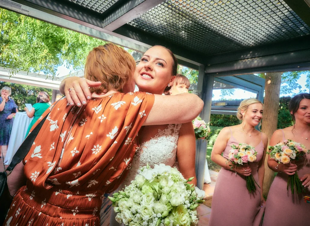 Jade embracing a wedding guest during her Hotel Miramar celebration