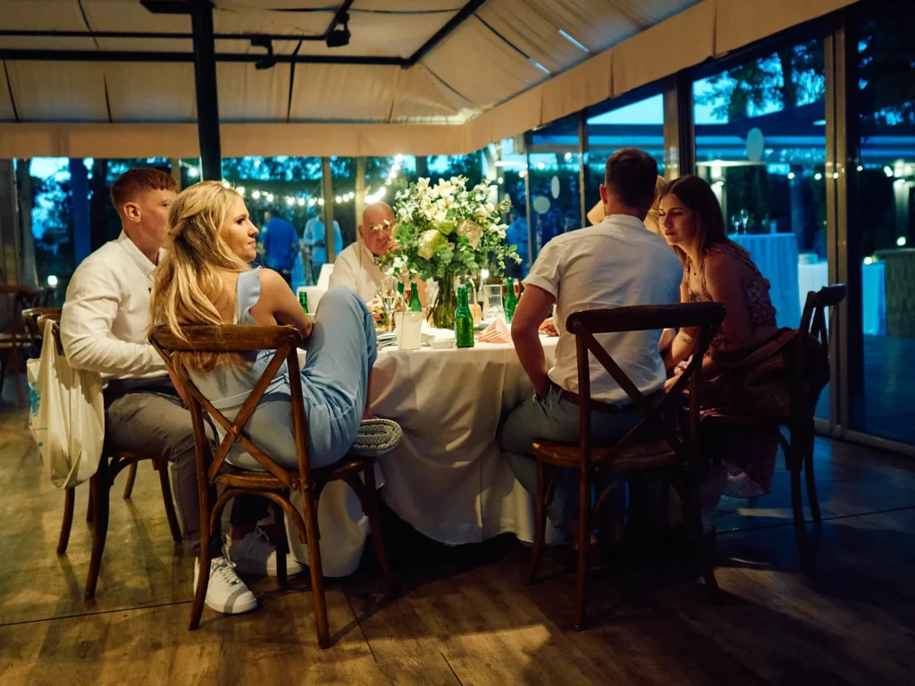 Wedding guests gathered for dinner after dark at Jade and Aidhan’s Hotel Miramar wedding