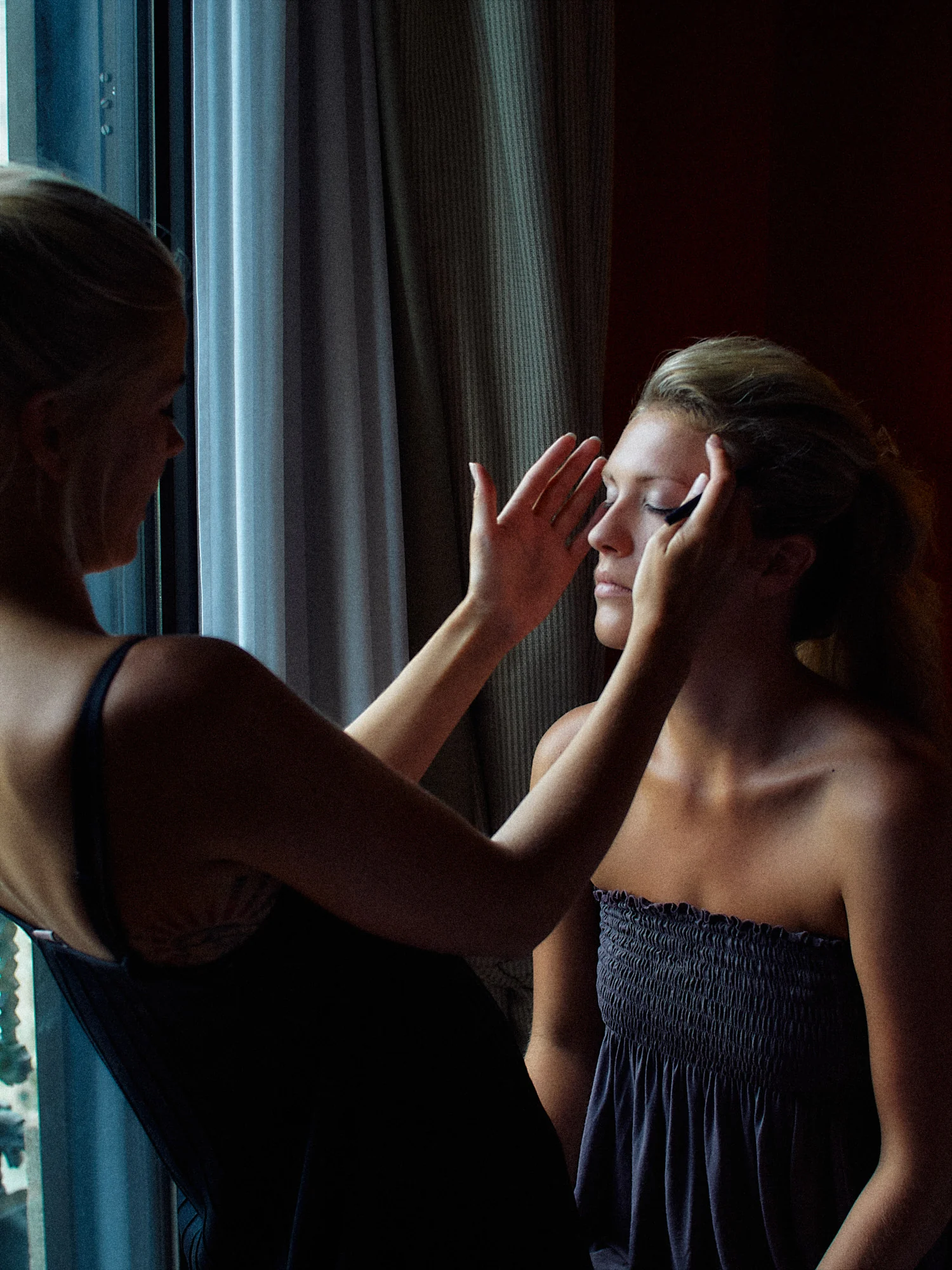 Jose and Kristy’s Barcelona Wedding – Bridal Makeup Bride having her makeup applied by a window before her Barcelona wedding