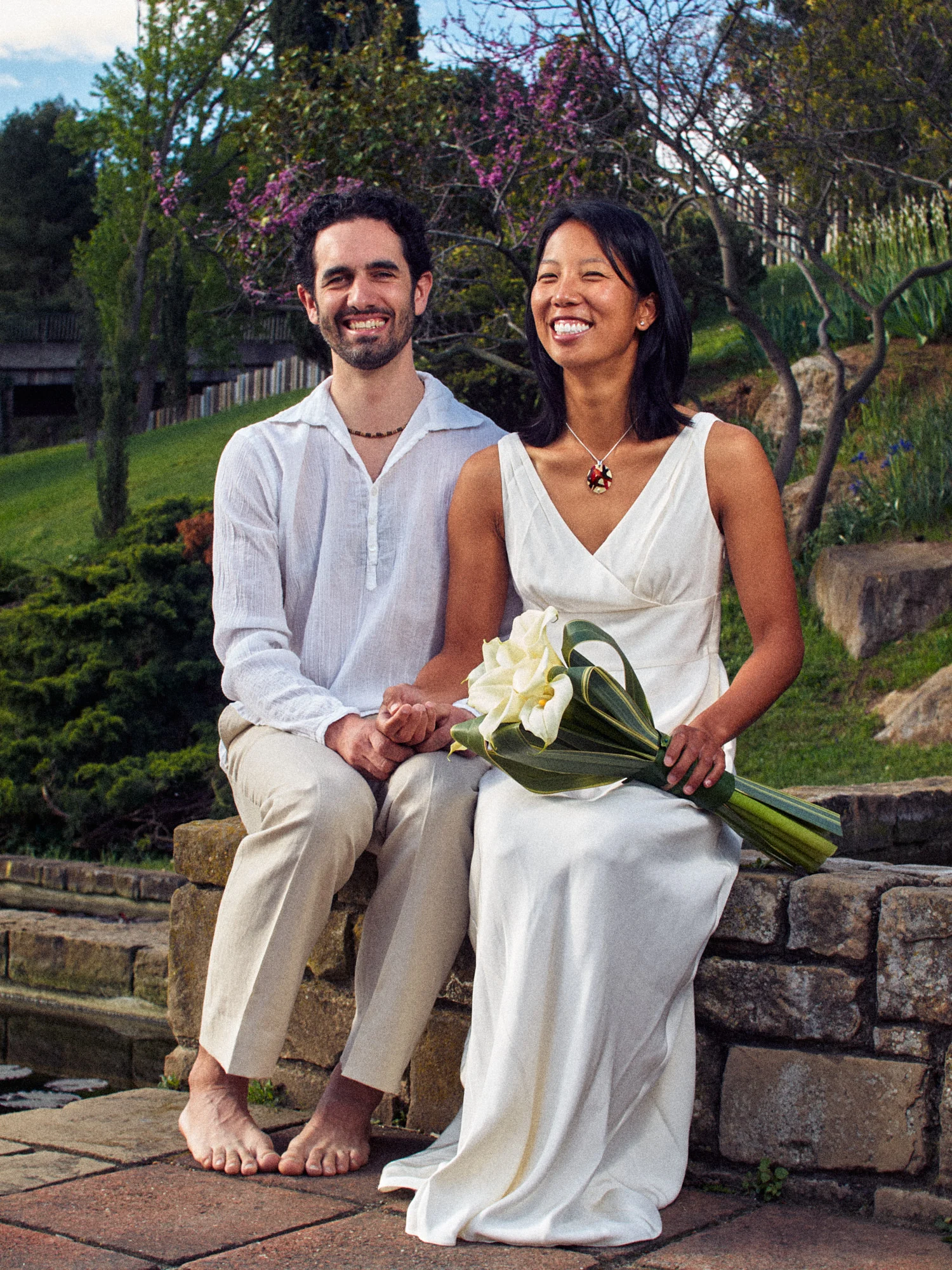 Rod and Vanessa seated together with their bouquet in Montjuïc gardens