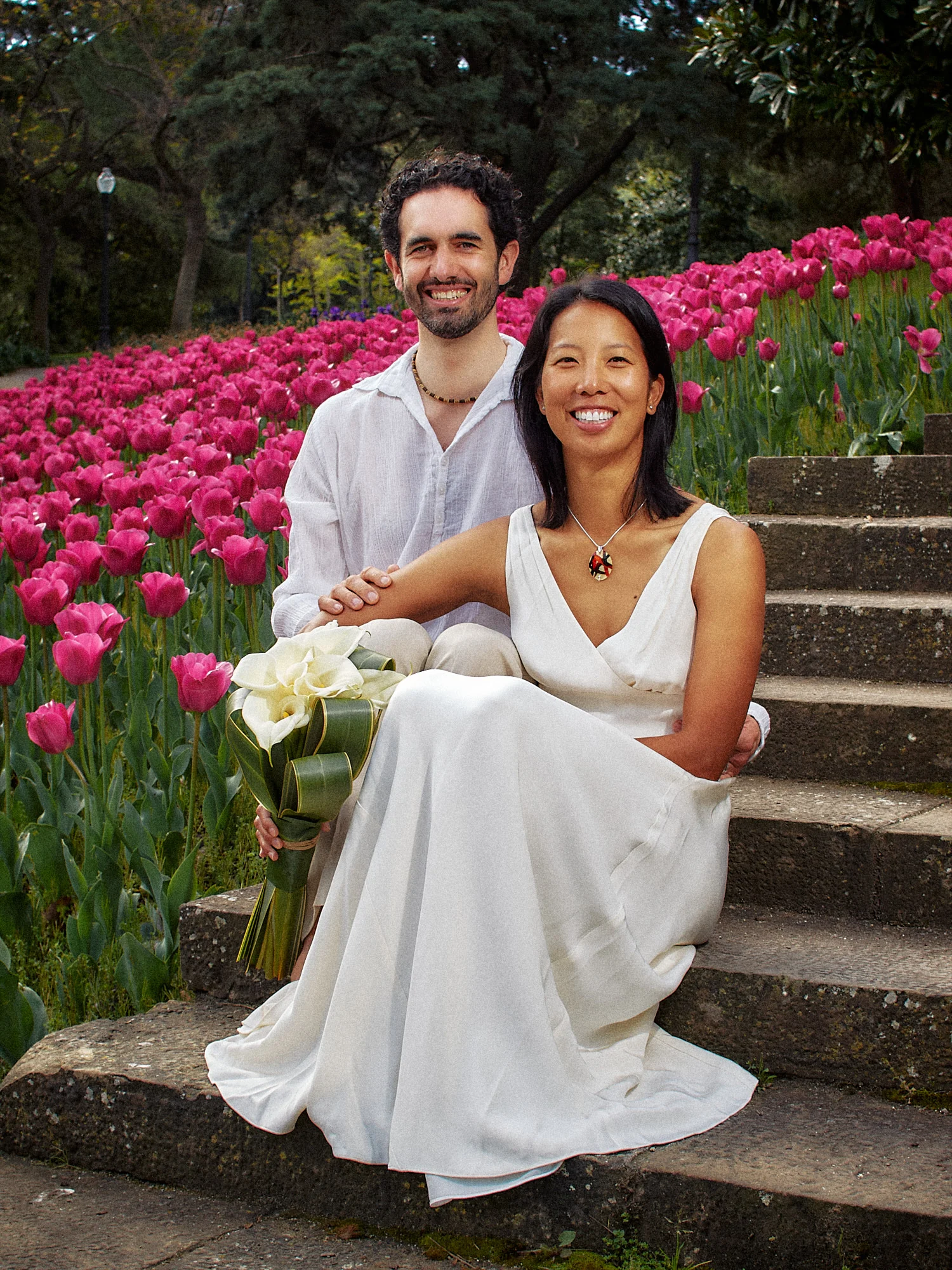 Rod and Vanessa sitting among pink flowers in Montjuïc gardens